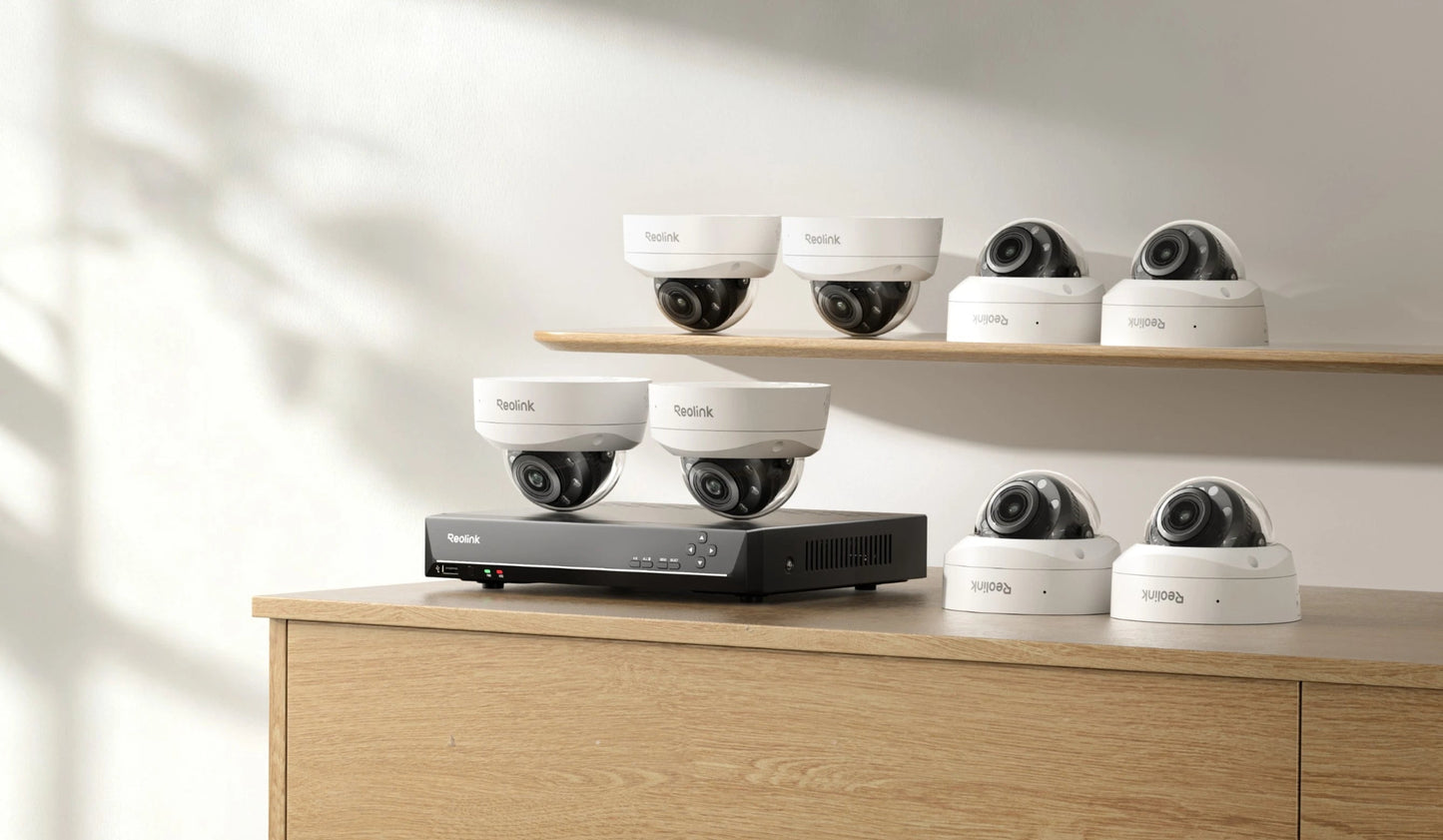 Set of security cameras and a DVR on a wooden surface with a neutral background
